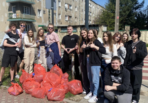 uczniowie z workami wypełnionymi zebranymi śmieciami