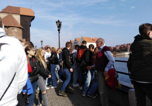 uczestnicy wycieczki słuchają przewodnika podczas spaceru po Starym Mieście w Gdańsku