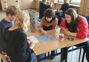 uczniowie grają w grę planszową